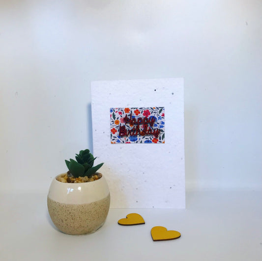 Seeded, plantable greeting card. With hand painted red, wooden happy birthday motif with floral background.