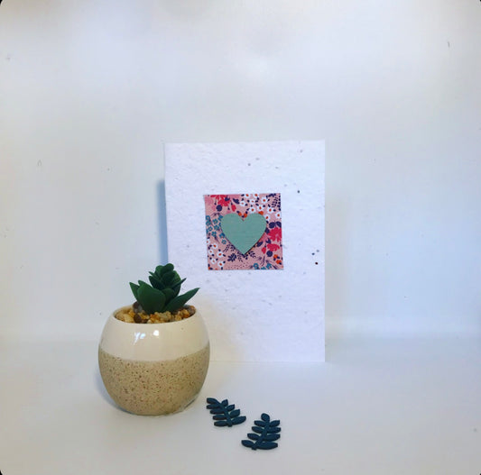 Seeded, plantable greeting card. With hand painted green, wooden heart motif with floral background.