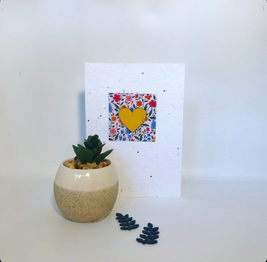 Seeded, plantable greeting card. With hand painted yellow, wooden heart motif with floral background.
